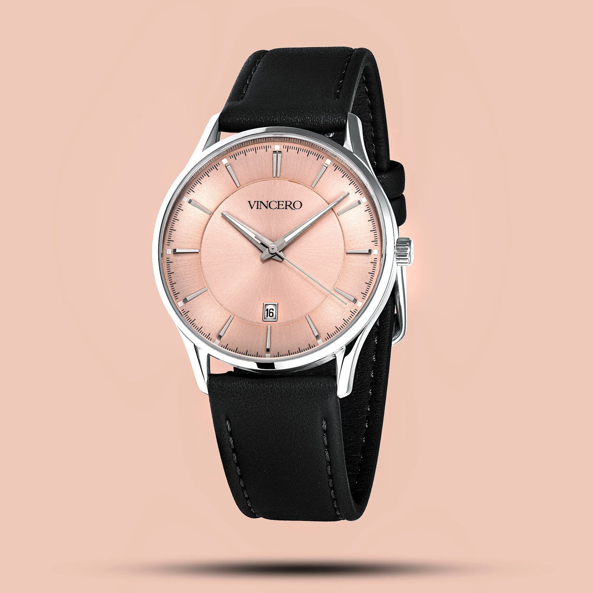Watch with black strap and pinkish-beige dial on a beige background