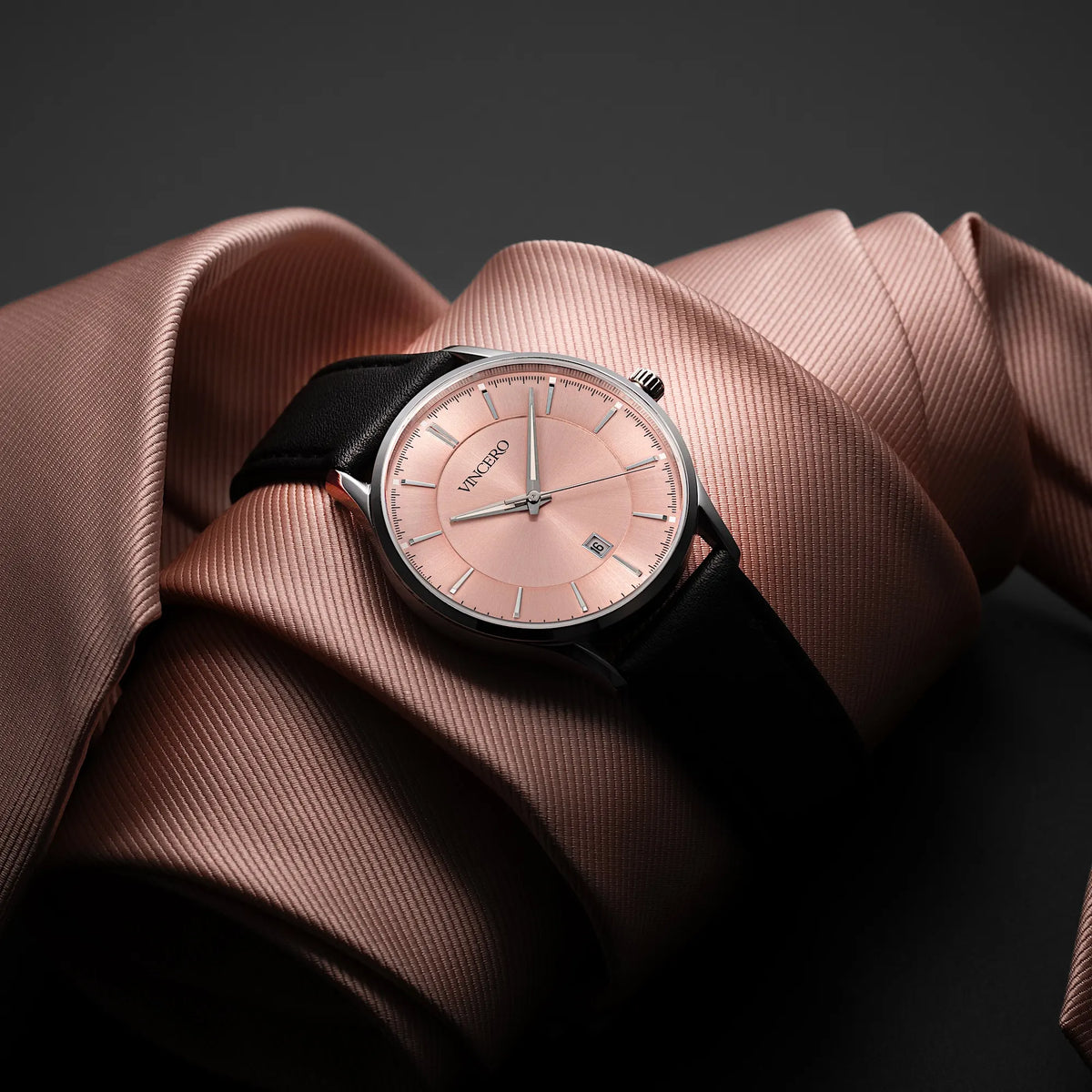 Luxury watch with a pink dial on a brown fabric background