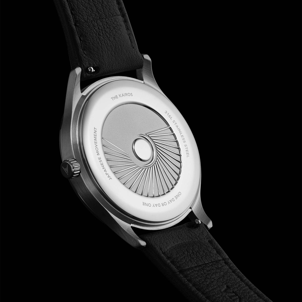 Watch with a black strap and silver dial on a black background