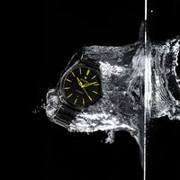 Watch emerging from a block of ice with water splashes on a black background