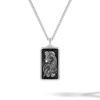 Silver pendant with intricate design on a white background