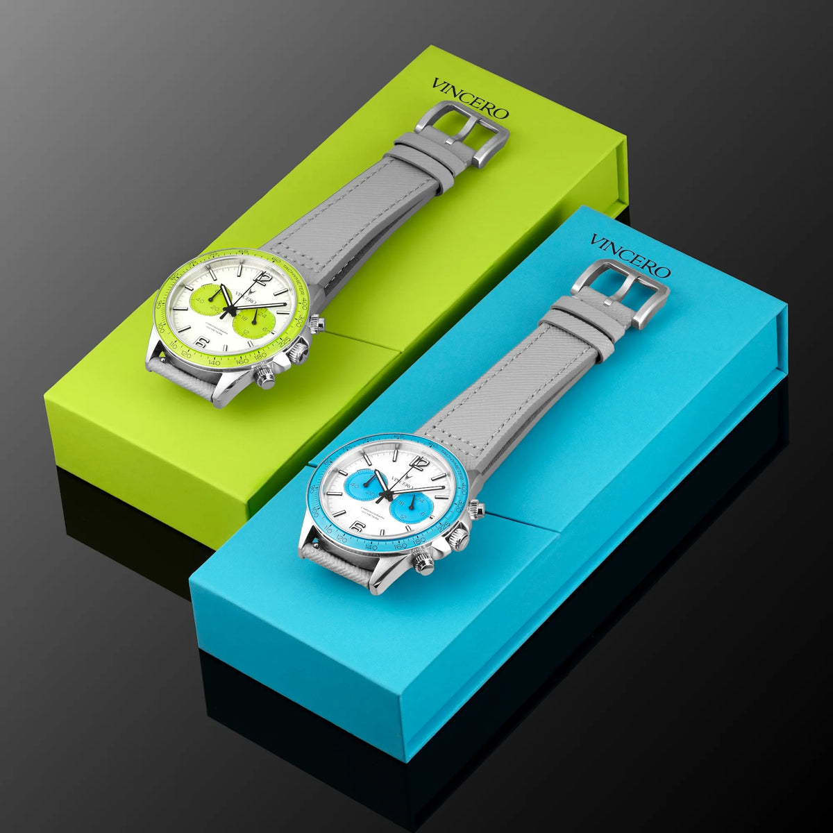 Two watches with gray straps on green and blue display stands, branded 'Vincero'.