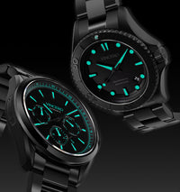 Two black wristwatches with green glowing faces on a black background