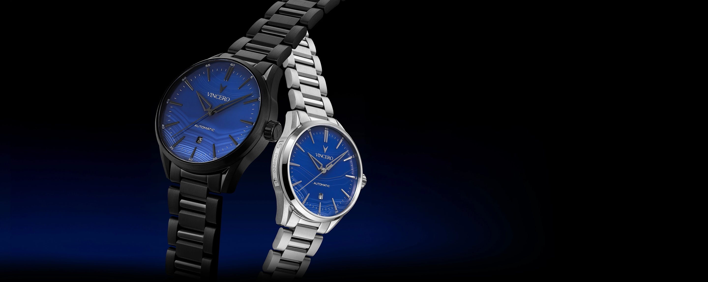 Two watches, one black and one silver, with blue faces on a dark background
