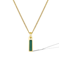 Gold necklace with a green pendant on a white background