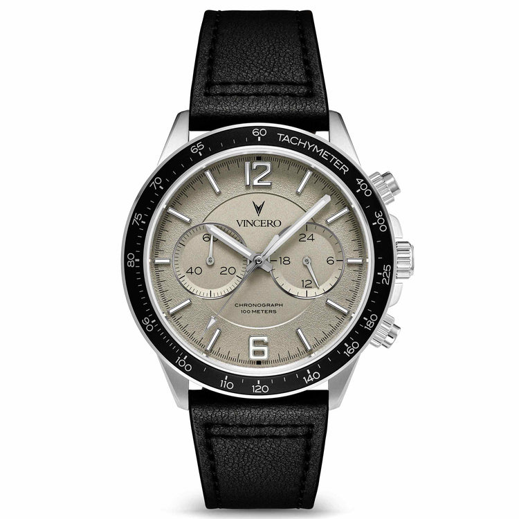 A silver-toned Vincero watch with a black leather strap and a white dial with black subdials, displayed against a plain background.