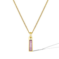 Gold necklace with a pink pendant on a white background