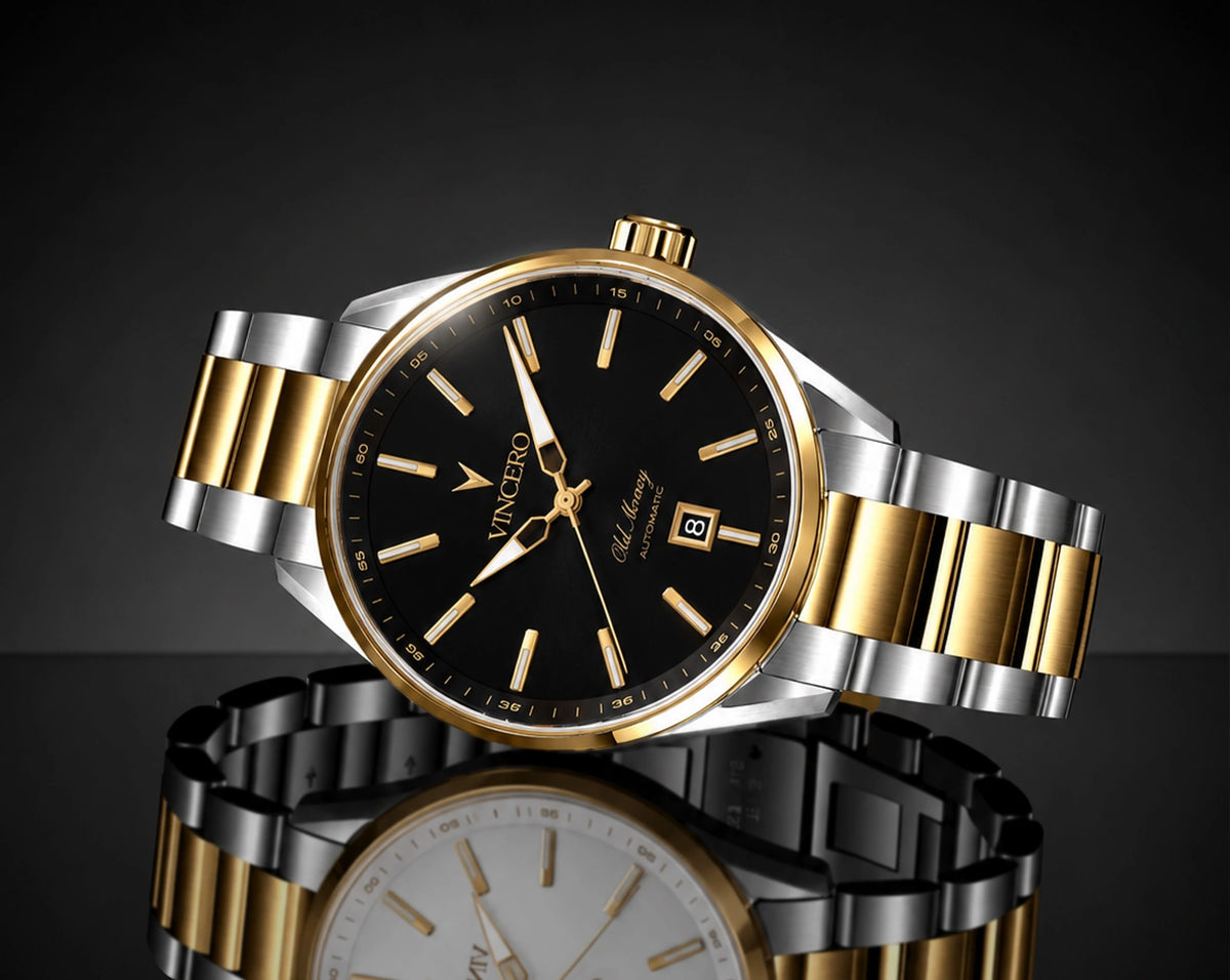 A luxury two-tone wristwatch with a black dial, gold-tone case and markers, and a silver-and-gold metal link bracelet, shown on a dark reflective studio background.