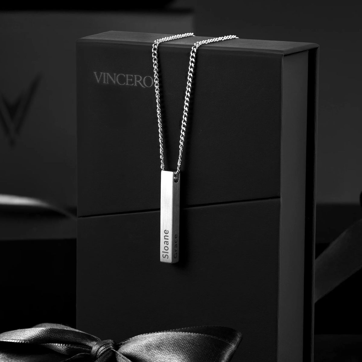 Silver necklace with a pendant on a black box, featuring the brand 'Vincero'.
