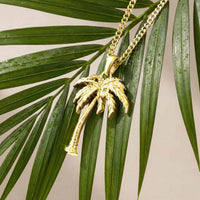 Gold palm tree pendant hanging from a tree 