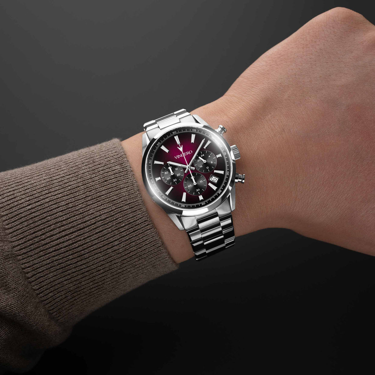 Silver watch on a wrist with a dark background