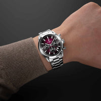 Silver watch on a wrist with a dark background