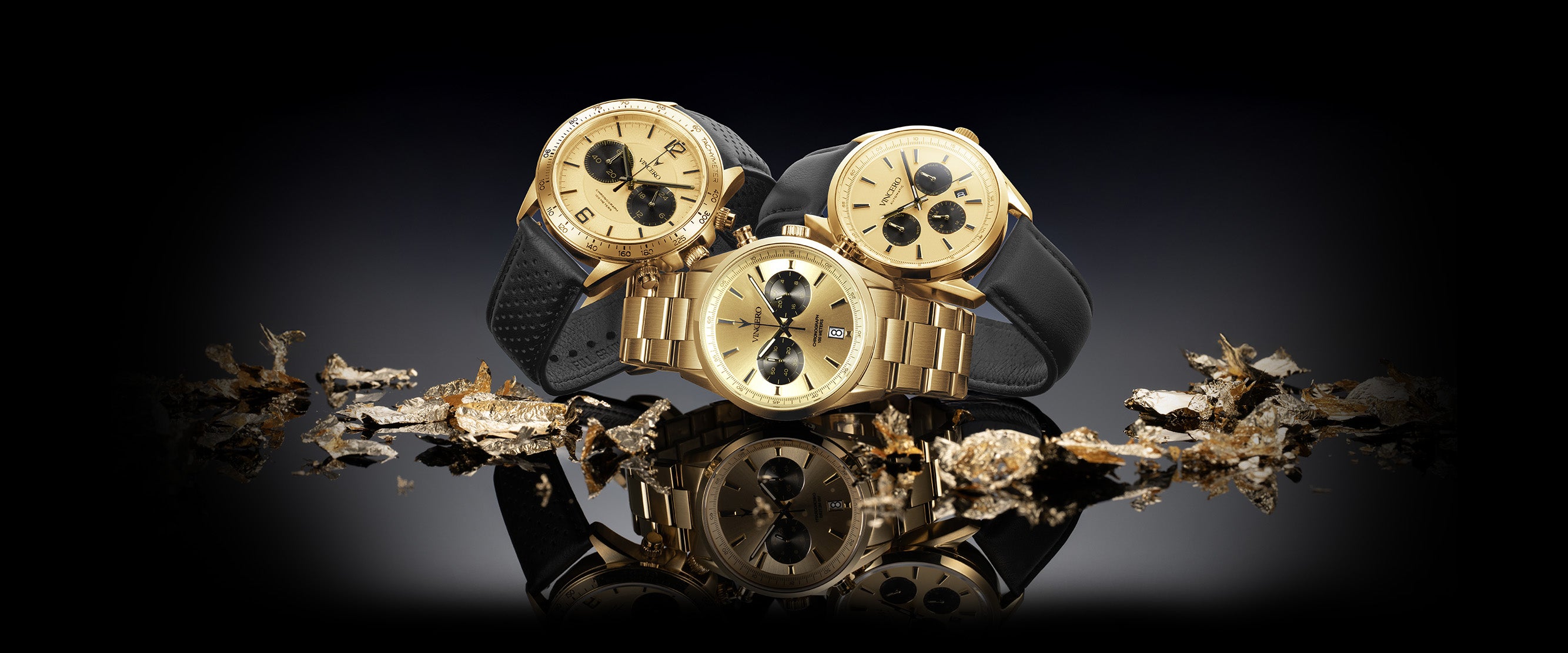 Gold and black skull-shaped jewelry on a reflective surface with a dark background