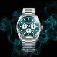 A silver stainless steel wristwatch with a green dial and three subdials, shown against a black background with glowing teal smoke effects. The brand name 'VINCERO' is visible on the watch face.