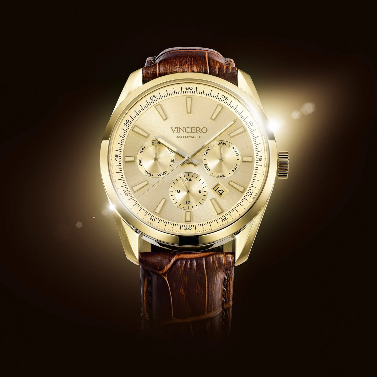 A luxury wristwatch by Vincero, featuring a gold-toned case, a cream-colored dial with three subdials, and a brown alligator-textured leather strap, set against a dark background with a soft light flare.