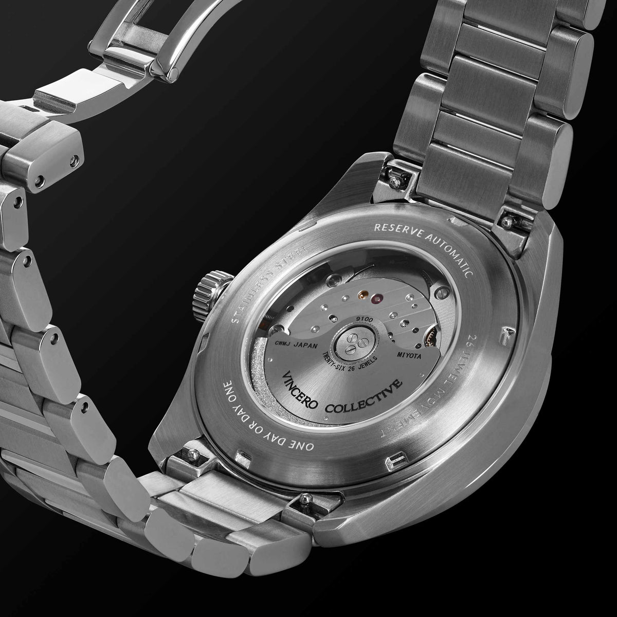 Close-up of a silver watch with visible brand name on a black background