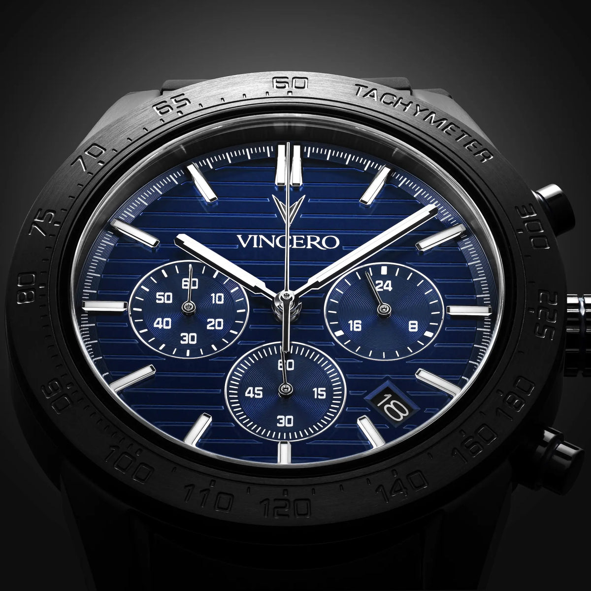 Luxury watch with blue face and black casing on a dark background