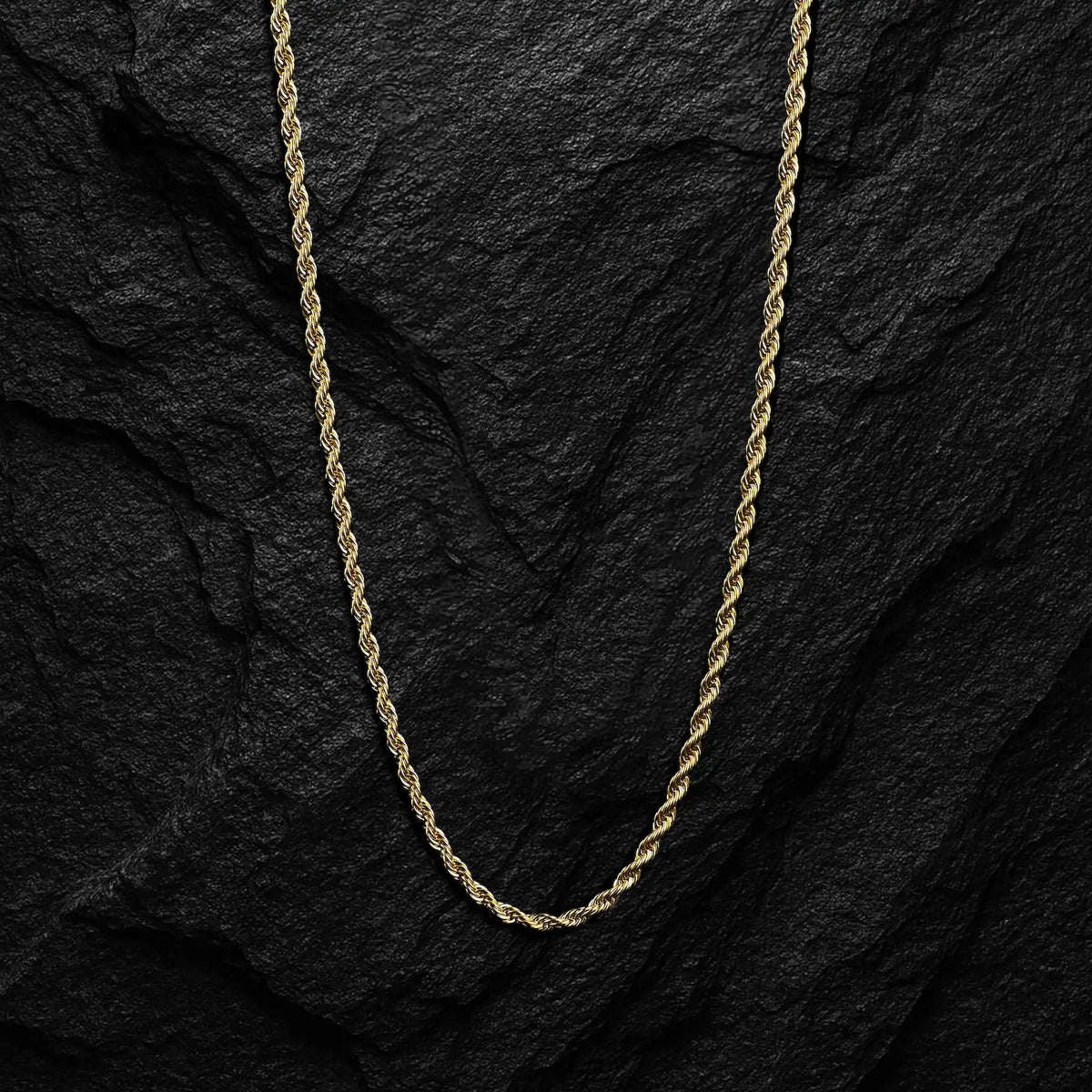 Gold rope chain on a black stone background