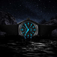 Watch with glowing blue numbers on a dark, rocky landscape