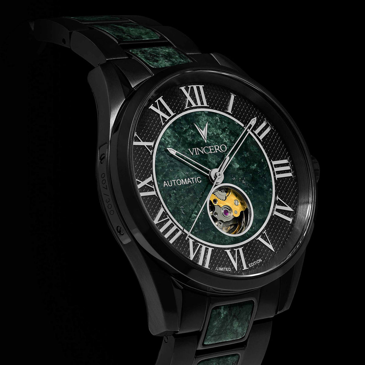Luxury watch with green face and black strap on a dark background
