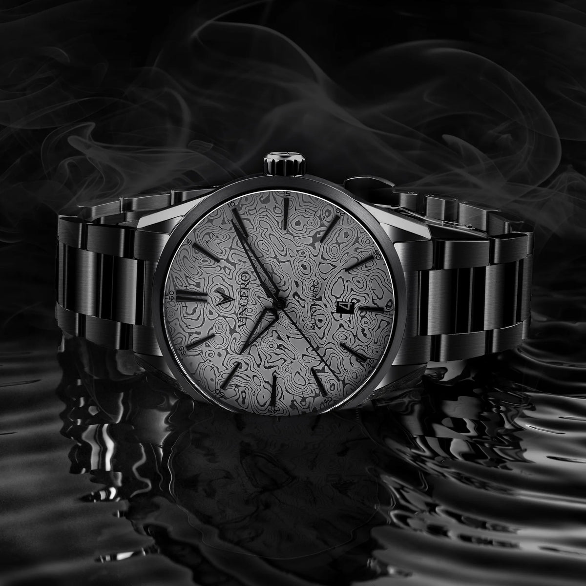 Silver watch with intricate design on a reflective surface and dark background