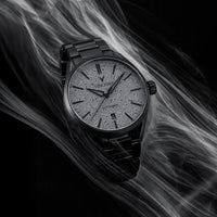 Black wristwatch with detailed face on a black and gray smoke background