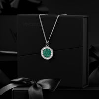 Silver necklace with a green pendant on a black box with 'Vincero' branding.