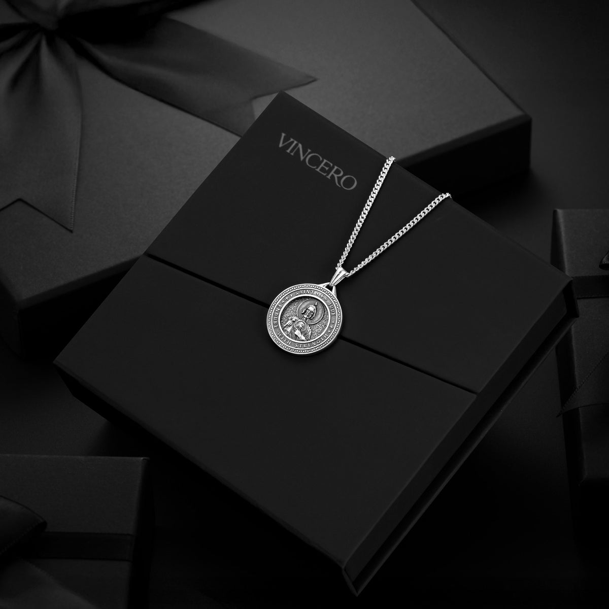 Silver necklace with a pendant on a black box labeled 'Vincero'.