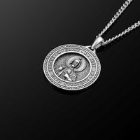 Silver pendant necklace on a black background