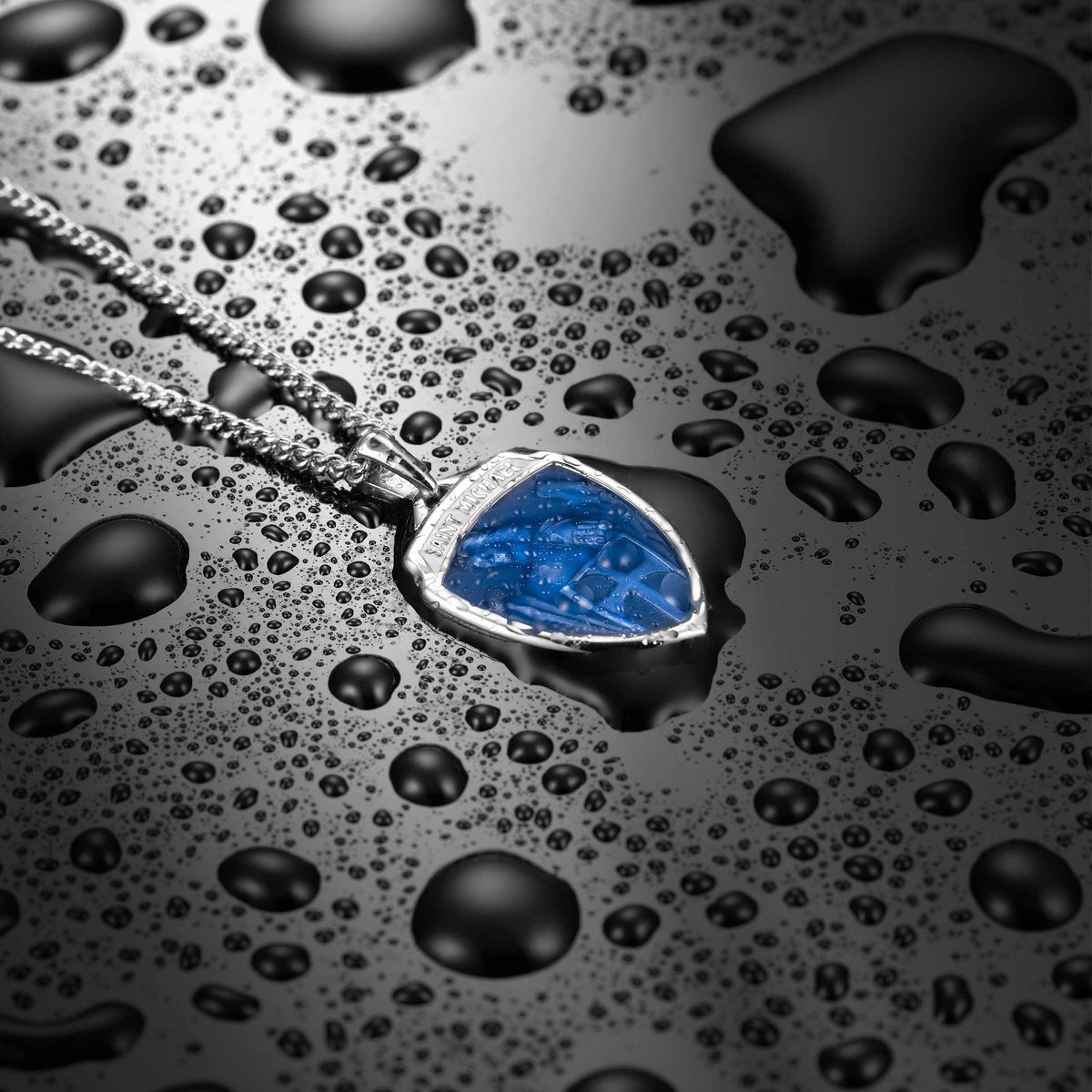 Jewelry necklace with a blue pendant on a wet surface