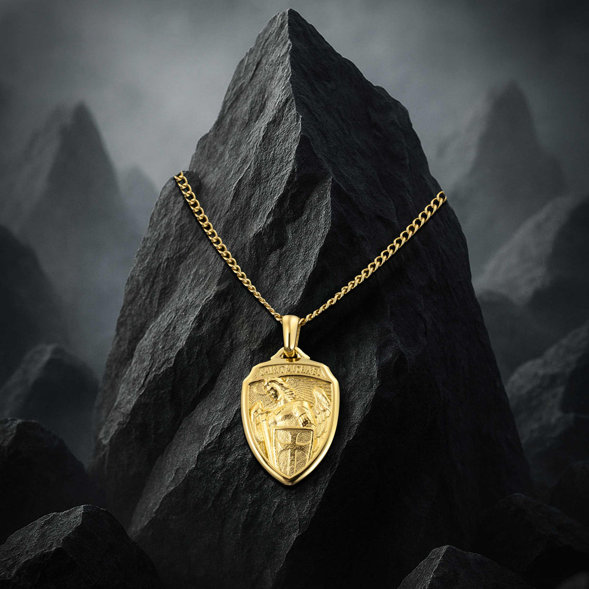 Gold necklace with a shield pendant on a dark rock with mountainous background