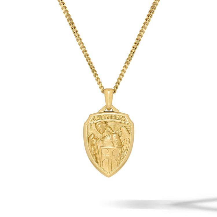 Gold necklace with a shield-shaped pendant on a white background