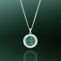 Silver necklace with a green pendant on a dark green background