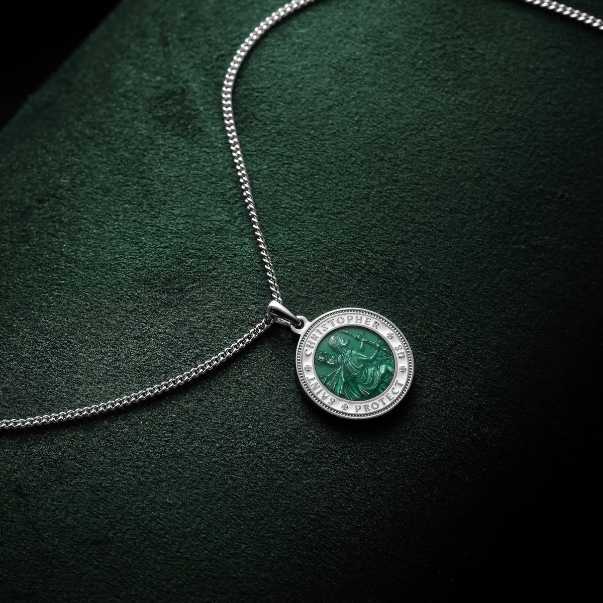 Silver necklace with a round pendant on a dark green background
