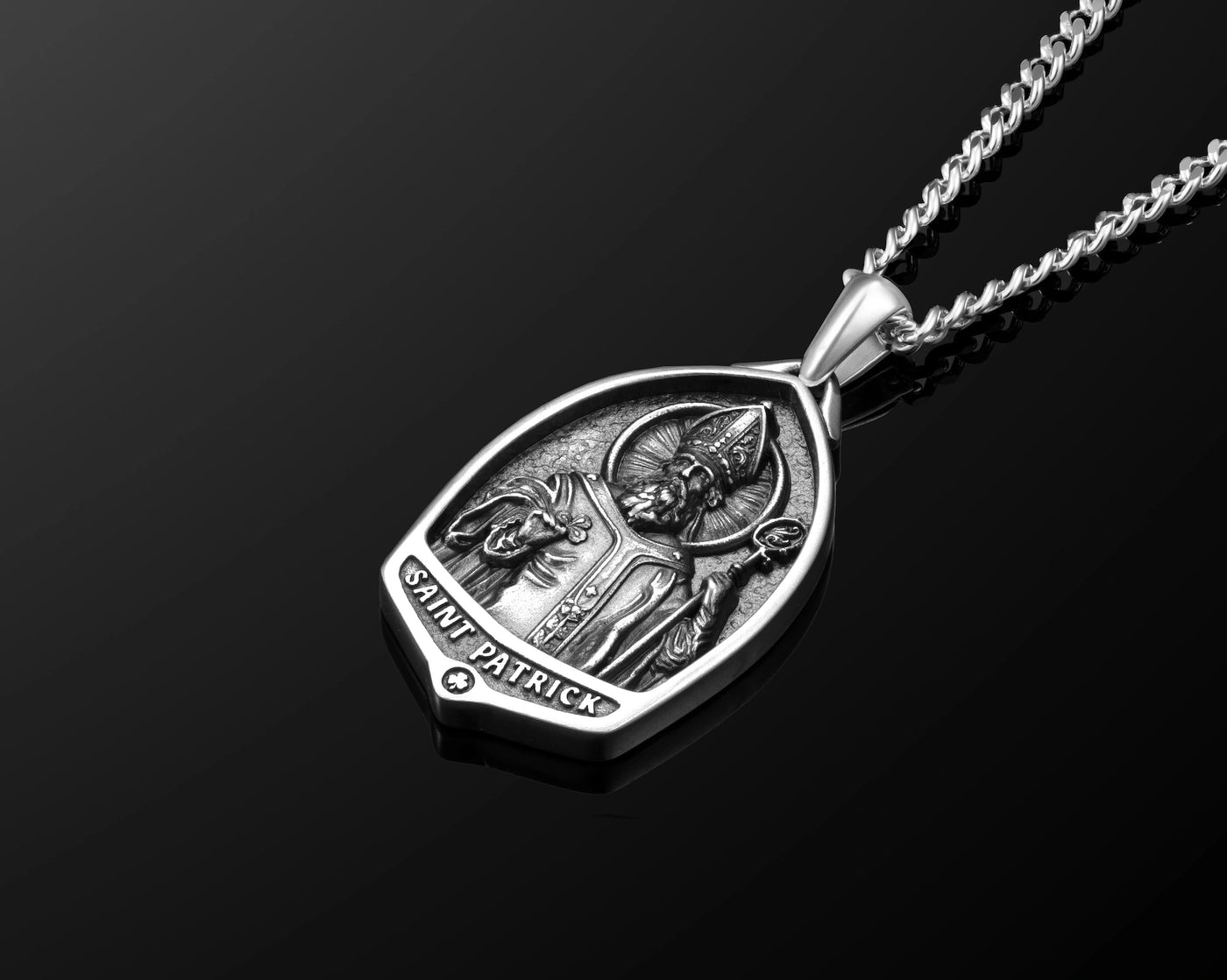 Silver pendant with 'Saint Patrick' engraving on a black background