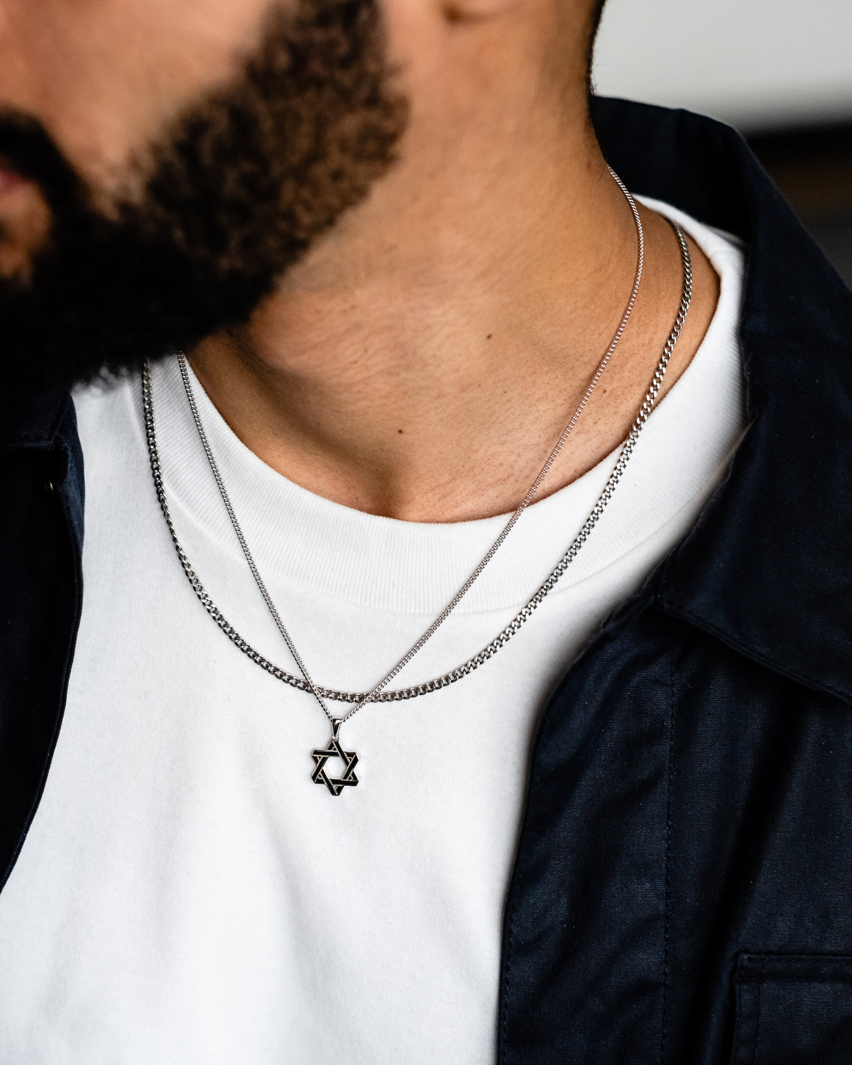 A sterling silver Star of David pendant necklace on a double curb chain.