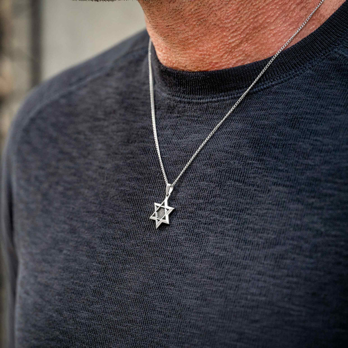 Man wearing silver chain necklace with silver Star of David pendant