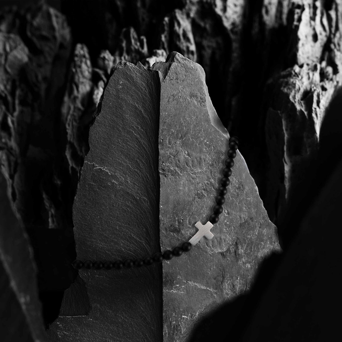 Rosary beads with a cross on a stone surface