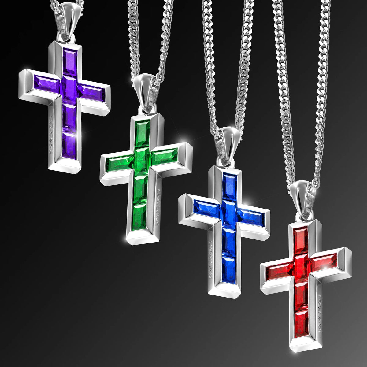 Four cross-shaped necklaces with colored centers on a black background