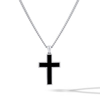 Black cross pendant on a silver chain against a white background