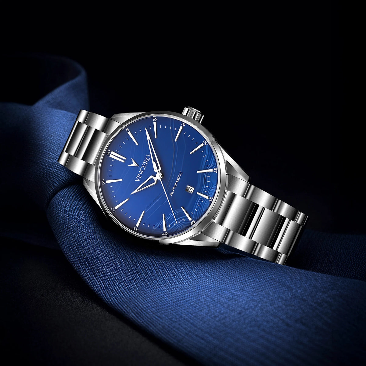 Silver watch with a blue face on a dark background