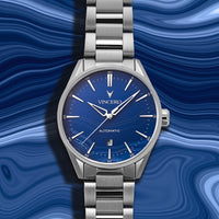 Silver wristwatch with blue dial on a blue wavy background