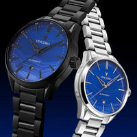 Two watches with blue faces and metal bands on a dark background