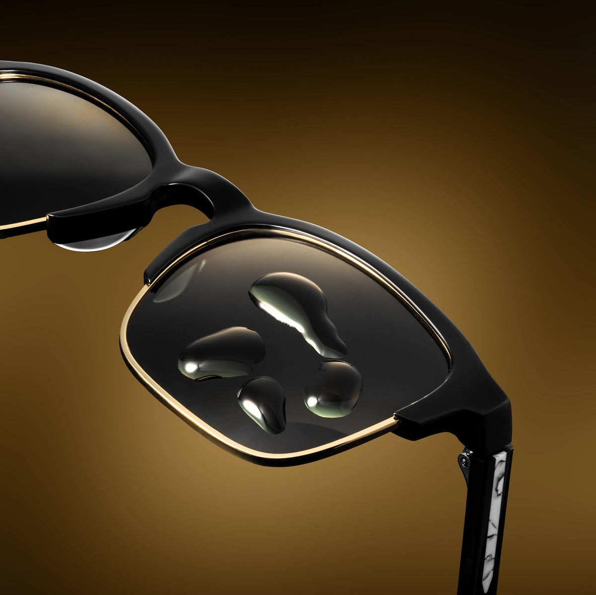 Close-up of a pair of black sunglasses with reflective lenses on a brown background