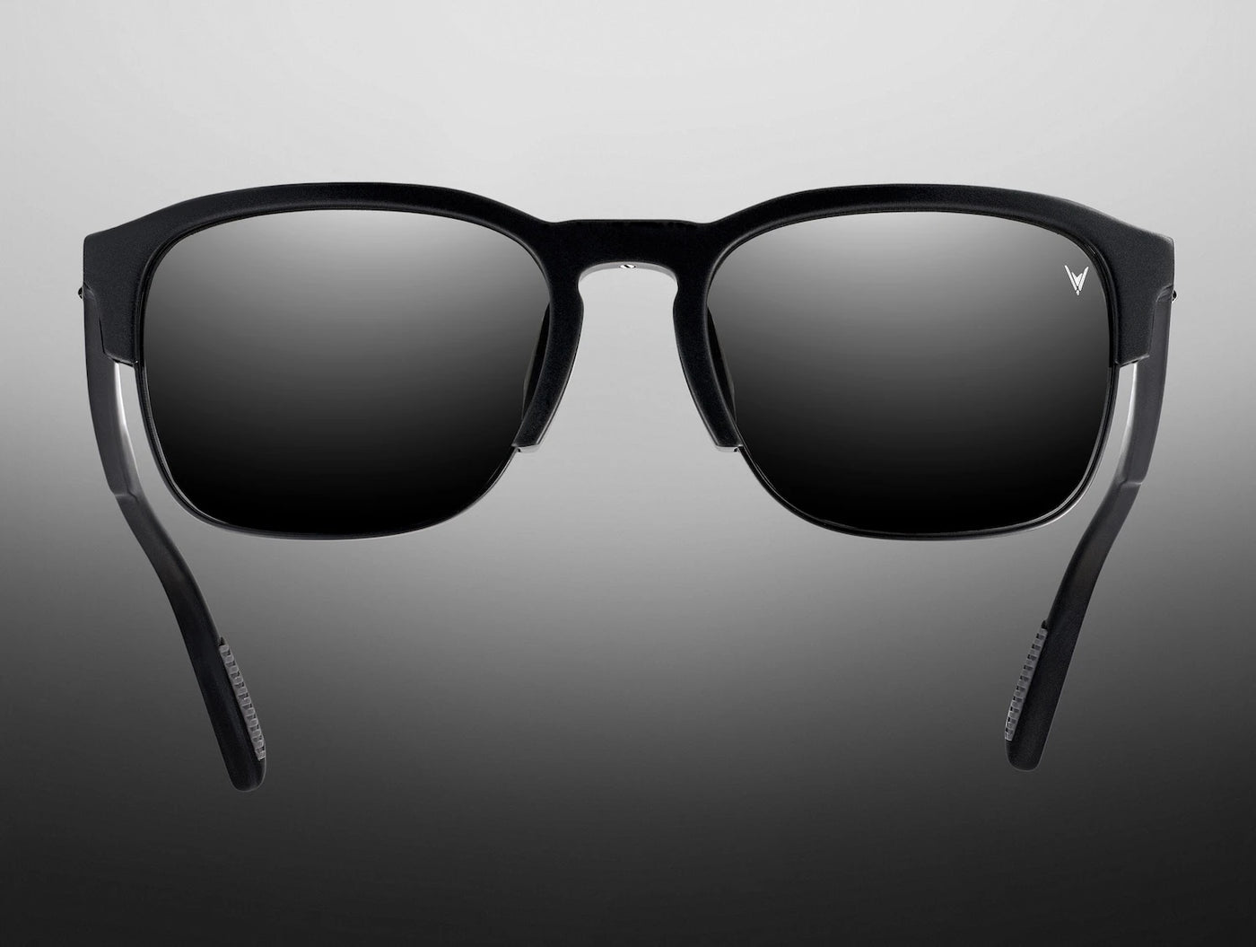 Black sunglasses with reflective lenses on a gray background