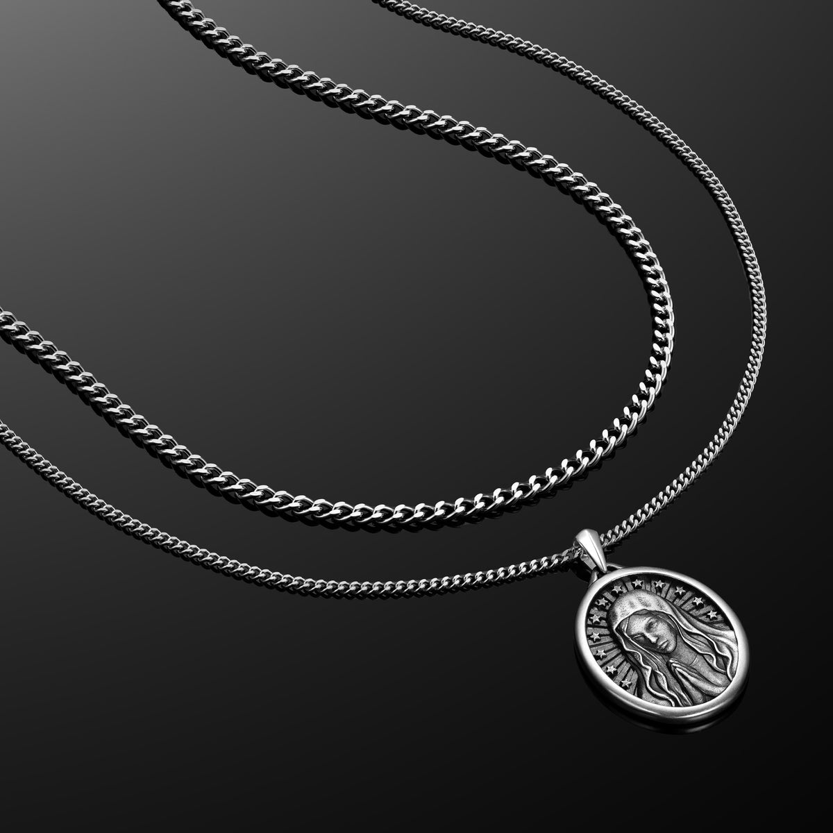 Silver chain necklace with a pendant on a black background