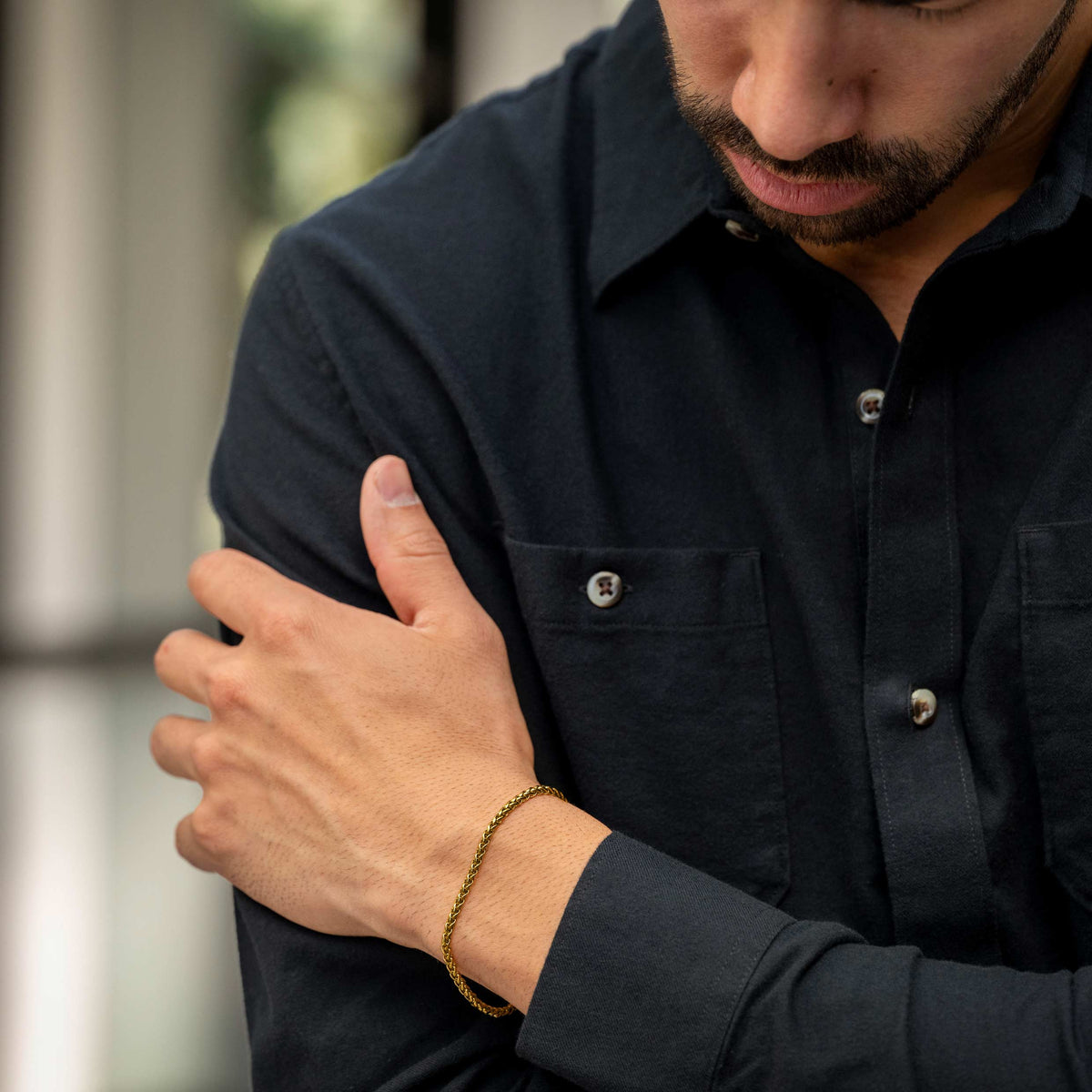 Man wearing a dark shirt with a blurred background