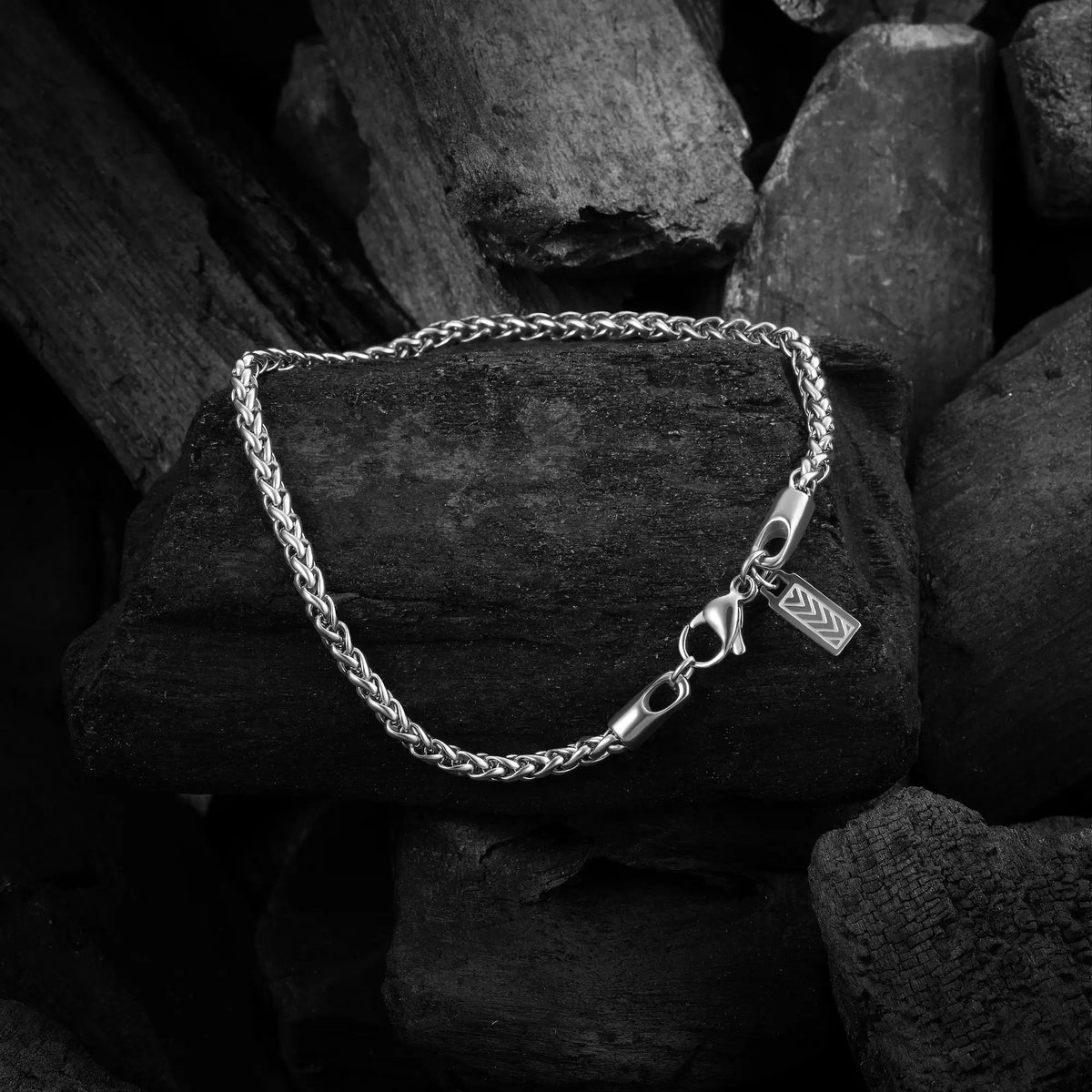 Silver bracelet with a clasp on dark stone background