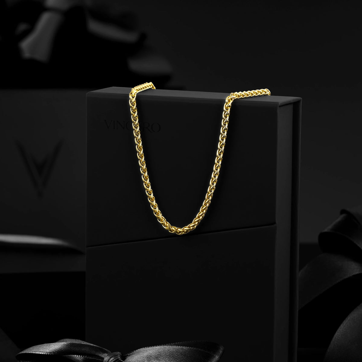 Gold chain on a black box with a dark background