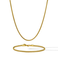 Gold chain necklace and bracelet set on a white background
